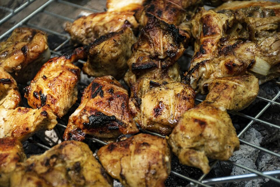 Grelha cheia de pedaços de frango a assar